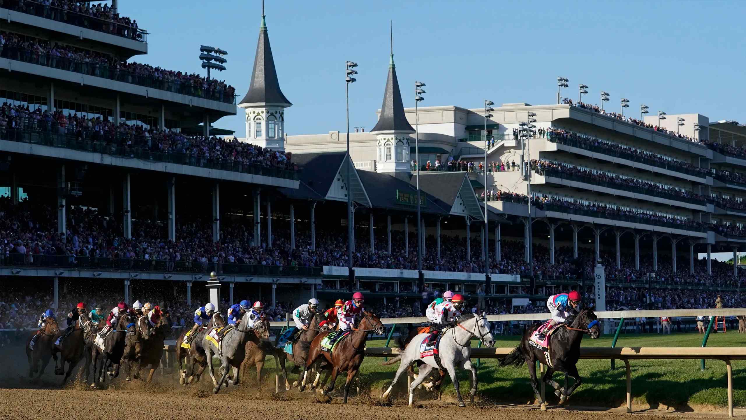 A tight pack of horses racing in the Kentucky Derby